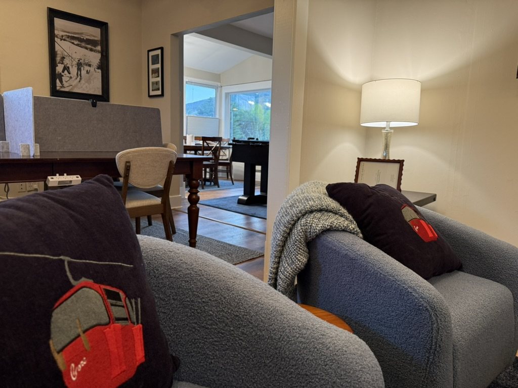 Inside Eiswork — bouclé armchairs with gondola cushions, a conference table, and a vintage North Creek ski photograph on the wall